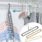 Load image into Gallery viewer, Folding hanger with multiple hooks on a rack, for hanging clothes.